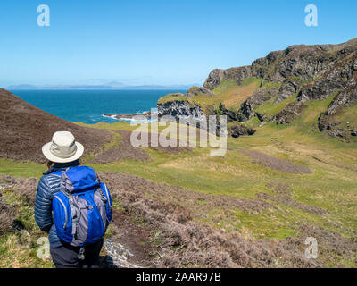 Tourist looking toward sea cliffs at Pig's Paradise,Isle of Colonsay, Scotland, UK Stock Photo