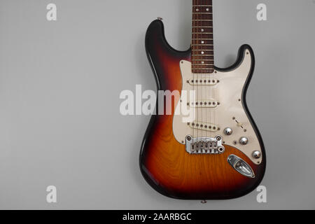 Body of an electric guitar against a grey background Stock Photo