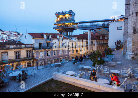 Lisbon, Portugal : Tourists sit at dusk at the Miradouro dos Terracos do Carmo view point, planned by architect Siza Vieira after the great Chiado dis Stock Photo