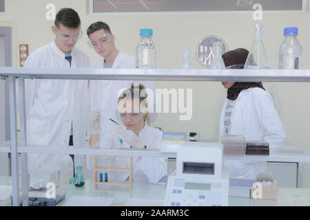 Group of young  scientists doing experiments in laboratory Stock Photo