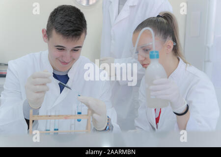Group of young  scientists doing experiments in laboratory Stock Photo