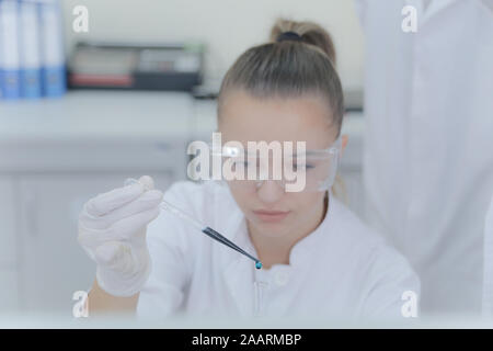 Young female scientist doing experiments in laboratory Stock Photo