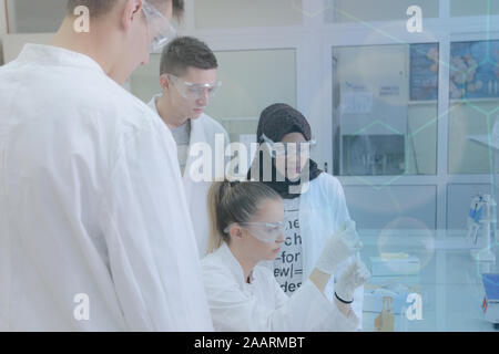 Group of young  scientists doing experiments in laboratory Stock Photo