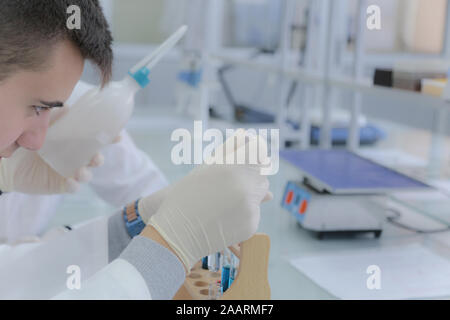 Young male scientist doing experiments in laboratory Stock Photo