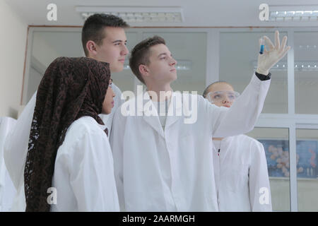 Group of young  scientists doing experiments in laboratory Stock Photo
