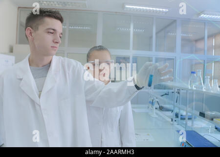 Two young students scientists doing experiments in laboratory Stock Photo