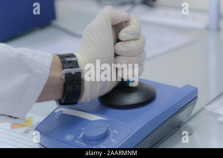 Technician loading a sample to centrifuge machine in the medical or scientific laboratory Stock Photo