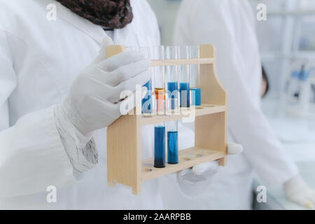 Female Research Scientist Uses Micropipette Filling Test Tubes in a Big Modern Laboratory. Stock Photo