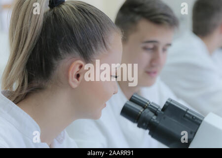 Two young male and female students scientists doing experiments in laboratory. Stock Photo