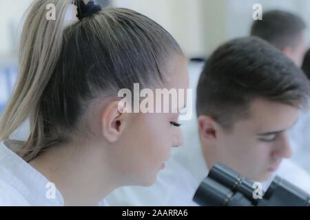 Two young male and female students scientists doing experiments in laboratory. Stock Photo