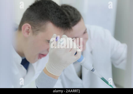 Two young male scientists doing experiments in laboratory Stock Photo