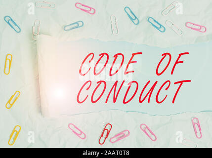 Text sign showing Code Of Conduct. Business photo text Ethics rules moral codes ethical principles values respect Paper clip and torn cardboard placed Stock Photo