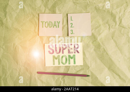 Handwriting text Super Mom. Conceptual photo a mother who can combine childcare and fulltime employment Papercraft craft paper desk square spiral note Stock Photo