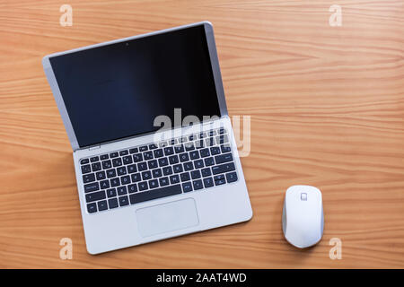 Modern laptop with white mouse over wood table Stock Photo