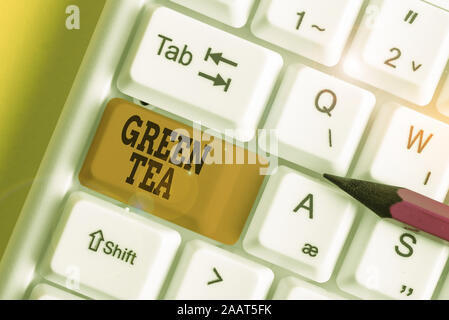 Word writing text Green Tea. Business photo showcasing type of tea that is made from Camellia sinensis leaves and buds White pc keyboard with empty no Stock Photo