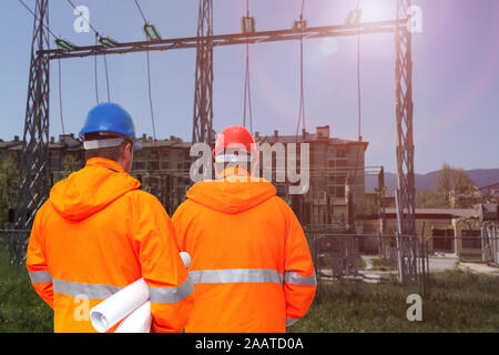 Two electrical engineers in substation, back view Stock Photo