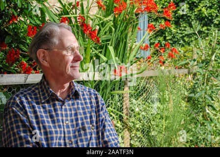 Elderly man enjoys sitting outdoors on a sunny day Stock Photo