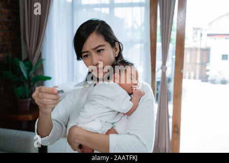 asian mother using thermometer feel worried about their children's health Stock Photo