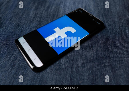 Odessa, Ukraine - October 26, 2019: Facebook app. Facebook logo visible on smartphone screen. Denim background. Soft focus Stock Photo