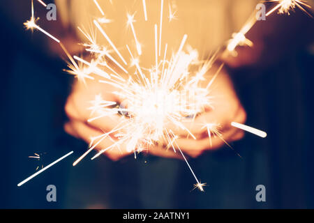 Close up hand woman holding sparklers in night party and christmas celebration.
