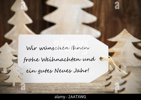 Label With German Text Frohe Weihnachten Und Ein Gutes Neues Jahr Means Merry Christmas And A Happy New Year. White Wooden Christmas Tree As Decoratio