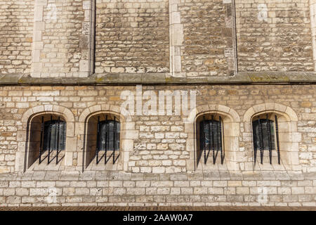 Abstract medieval brick wall with barred windows Stock Photo