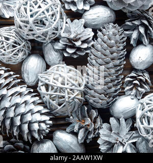 Flat lay silver background of fir and pine painted cones, nuts and wicker balls Stock Photo