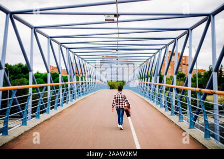 Gypsy boy with guitar walking across the bridge Stock Photo