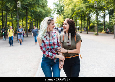 Two friends strolling together in a park having fun Stock Photo
