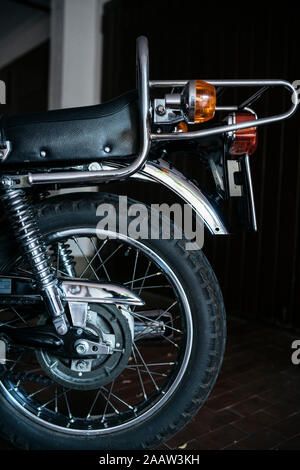 Back wheel of vintage motorbike parked in garage Stock Photo