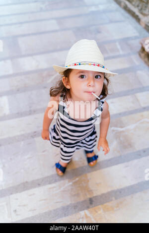 Portrait of little girl sucking lollipop in summer Stock Photo