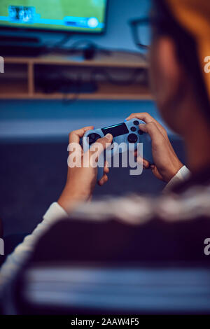 Close-up of teenage boy playing video game in an amusement arcade Stock Photo