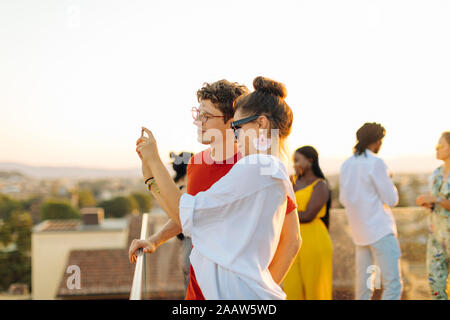 Young woman and man taking a selfie during a party in the evening Stock Photo