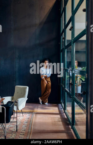 Portrait of young businesswoman standing at the window in loft office Stock Photo