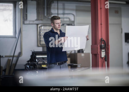 Young man in a printing company checking the print Stock Photo