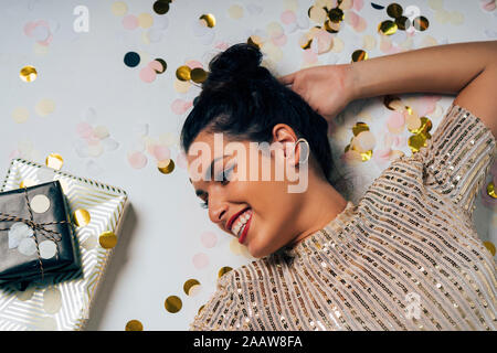 Portrait of young woman dressed for a party, celebrating Christmas with gifts Stock Photo