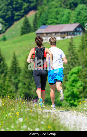 Young people doing a running session in green alpine nature Stock Photo