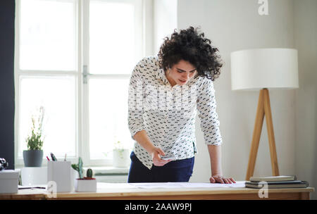 Young woman studying a plan on desk in office Stock Photo