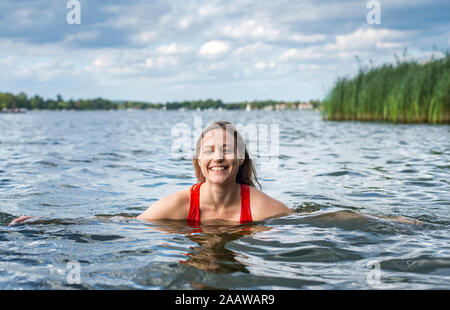 Portrait of a smiling woman bathing in a lake Stock Photo