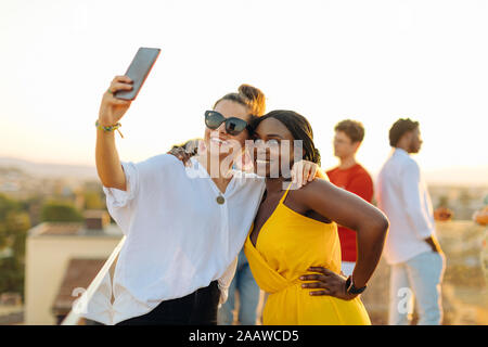 Young women taking a selfie during a party in the evening Stock Photo