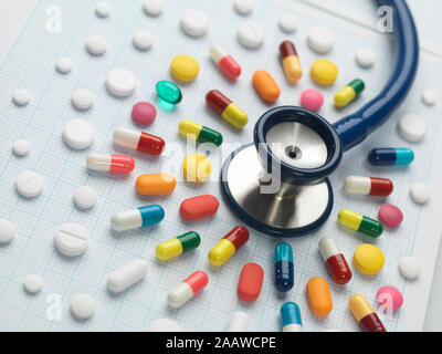 High angle view of stethoscope with various medicines arranged on graph