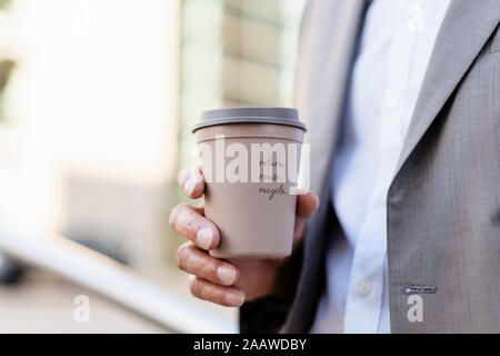 Close-up of businessman holding reusable takeaway coffee cup Stock Photo