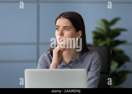 Pensive female employee look in distance thinking Stock Photo