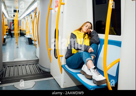 Young woman sleeping in underground train Stock Photo
