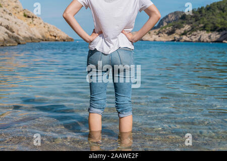 Young woman standing in water at the beach Stock Photo