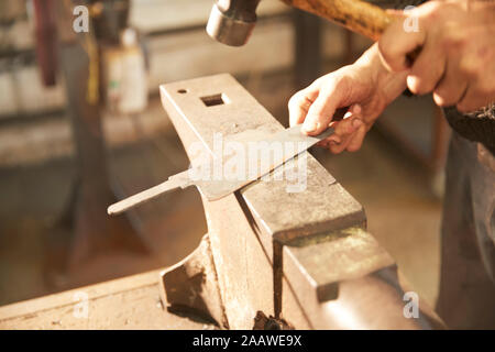 Man finishing blade on an anvil Stock Photo