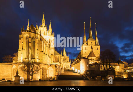 Illuminated churches against cloudy sky in Erfurt at night, Germany Stock Photo