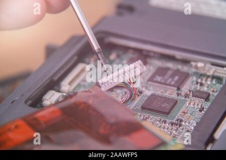 Computer service. Man repairing notebook at the table Stock Photo