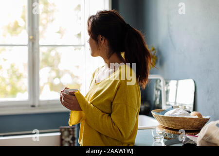 woman drinking tea in office kitchenet Stock Photo