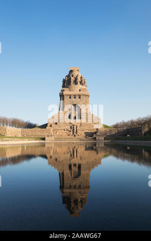 Lake of tears with reflection of Völkerschlachtdenkmal against clear blue sky, Saxony, Germany Stock Photo